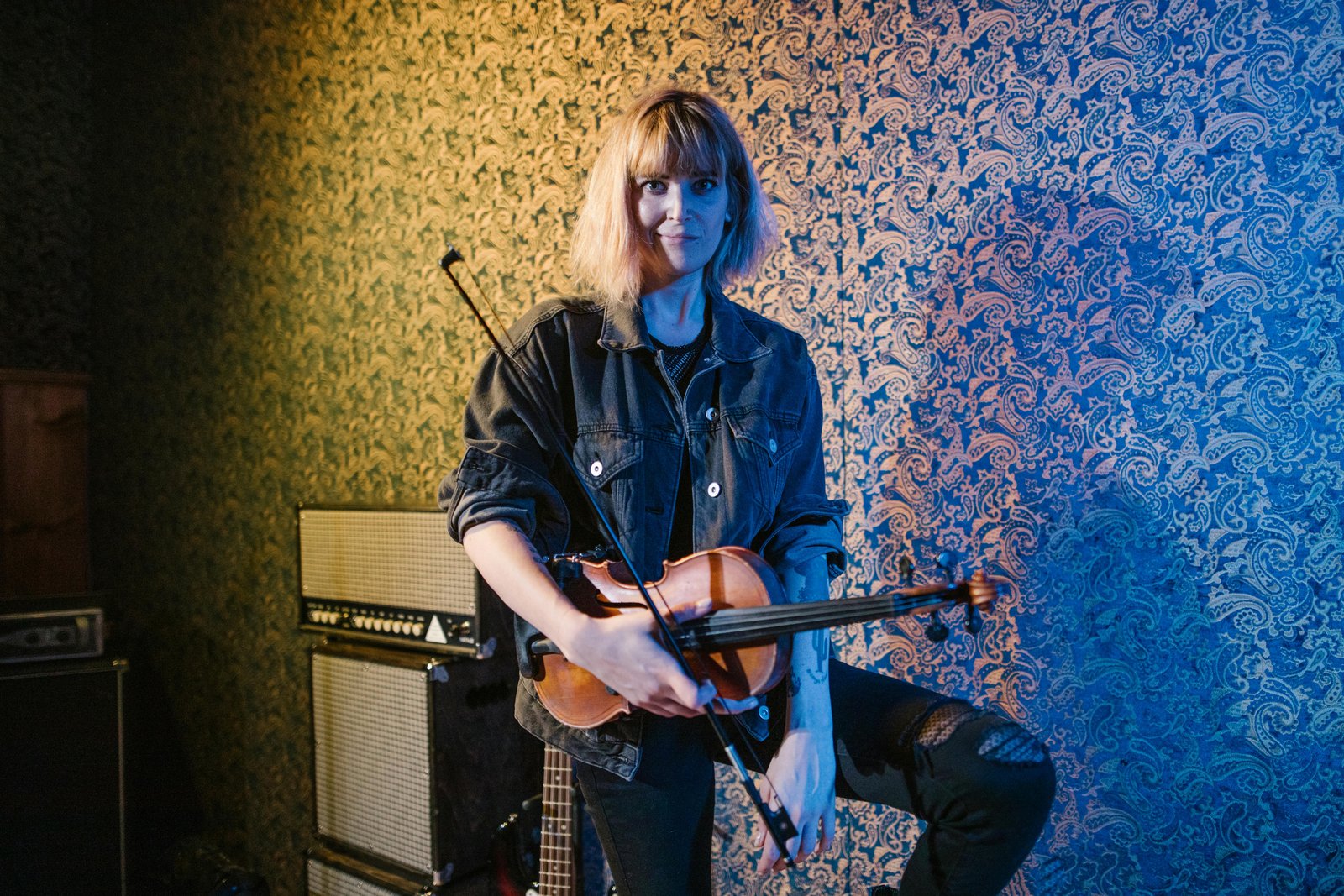 Portrait d’une personne entourée d’objets symbolisant ses multiples passions (livres, instruments, outils numériques)